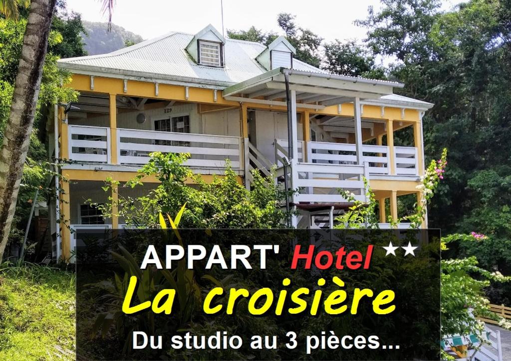 GourbeyreAppart'hotel La croisière的黄色房子前面有标志
