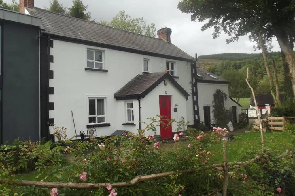 Ó MéithQuarvue Farmhouse, Unique house with views of Mournes and Cooleys的院子里有红色门的白色房子