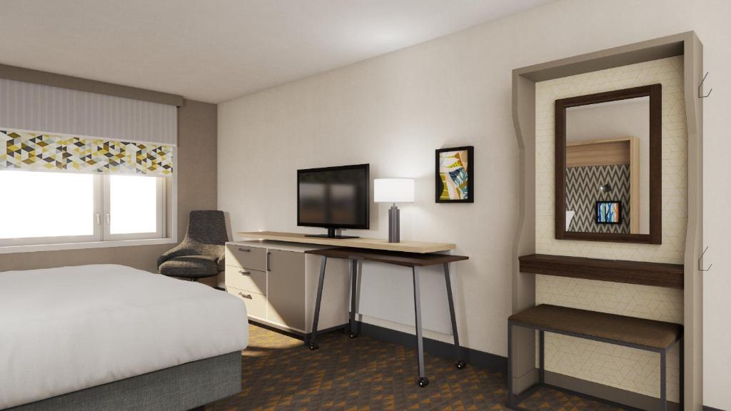芝加哥Holiday Inn Chicago Midway Airport S, an IHG hotel的一间卧室配有一张床和一张书桌及电视