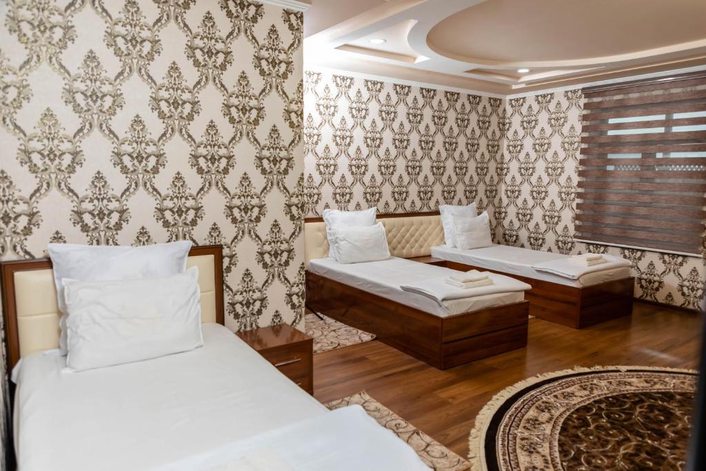 KokandRohat Hotel的一间带两张床和一张沙发的卧室