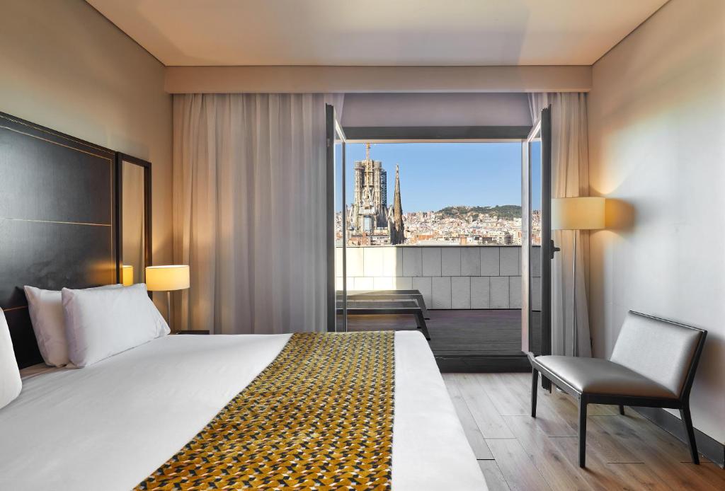 巴塞罗那欧洲之星丰碑酒店的酒店的客房 - 带一张床、椅子和窗户