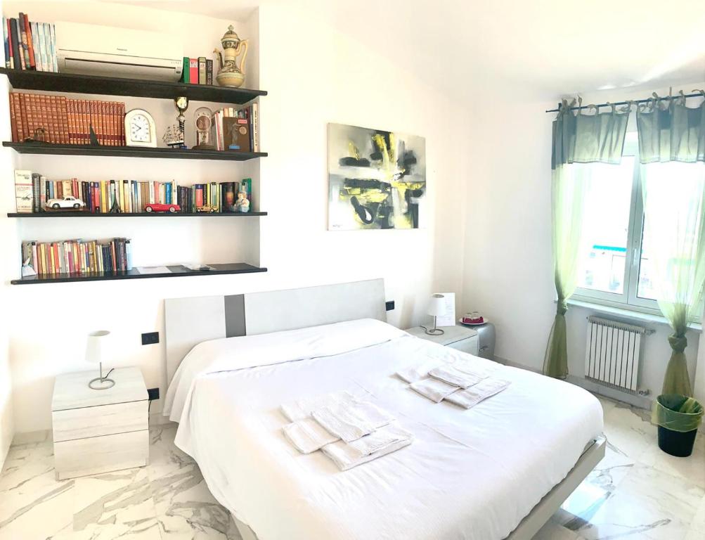 热那亚La Casa sui Tetti的卧室配有白色的床和书架