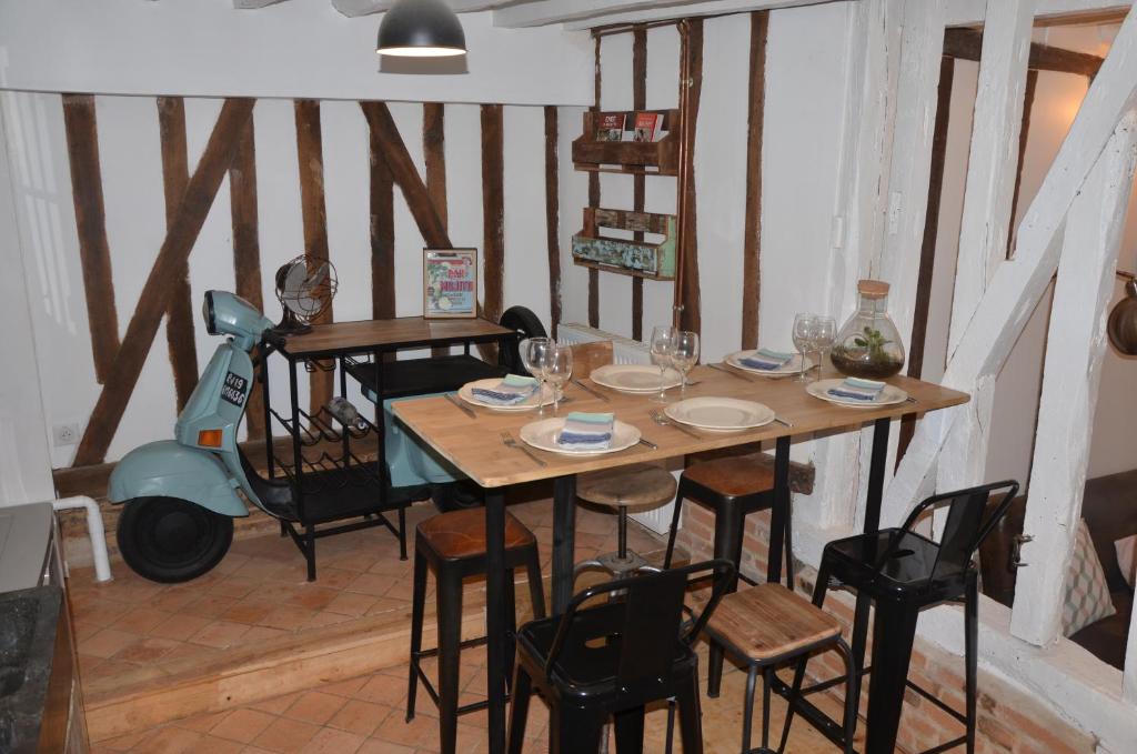 博韦LA PETITE BEAUVAISIENNE的用餐室配有桌椅和摩托车