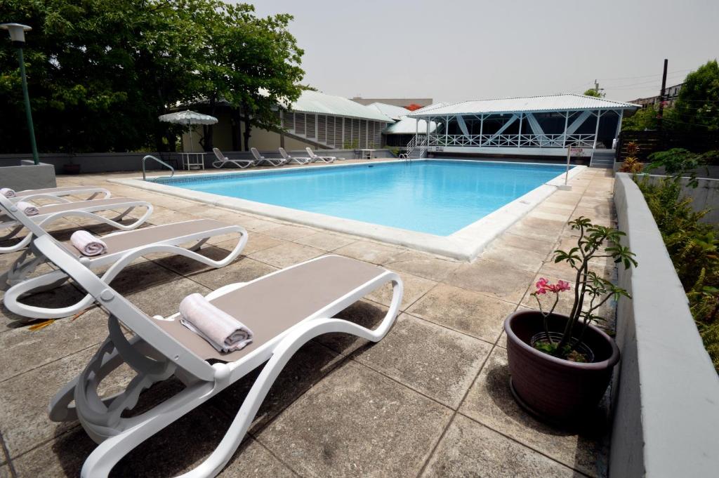 金斯敦利瓜尼亚俱乐部酒店的游泳池旁设有躺椅