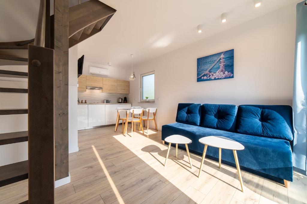 亚斯塔尔尼亚Marina Domki Apartamentowe的一间带蓝色沙发的客厅和一间厨房