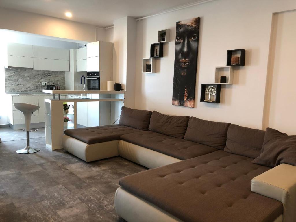 布加勒斯特Luxury Westpark 2 Residence Lake View W6的一间带棕色沙发的客厅和一间厨房