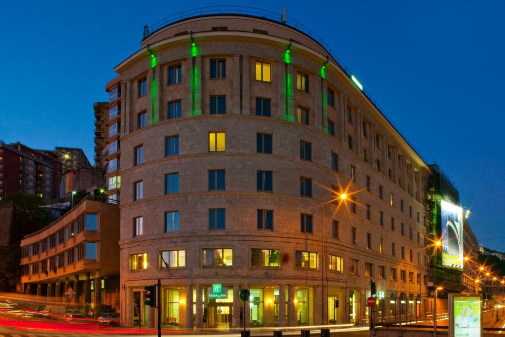 热那亚热那亚假日酒店的建筑的一侧有绿灯