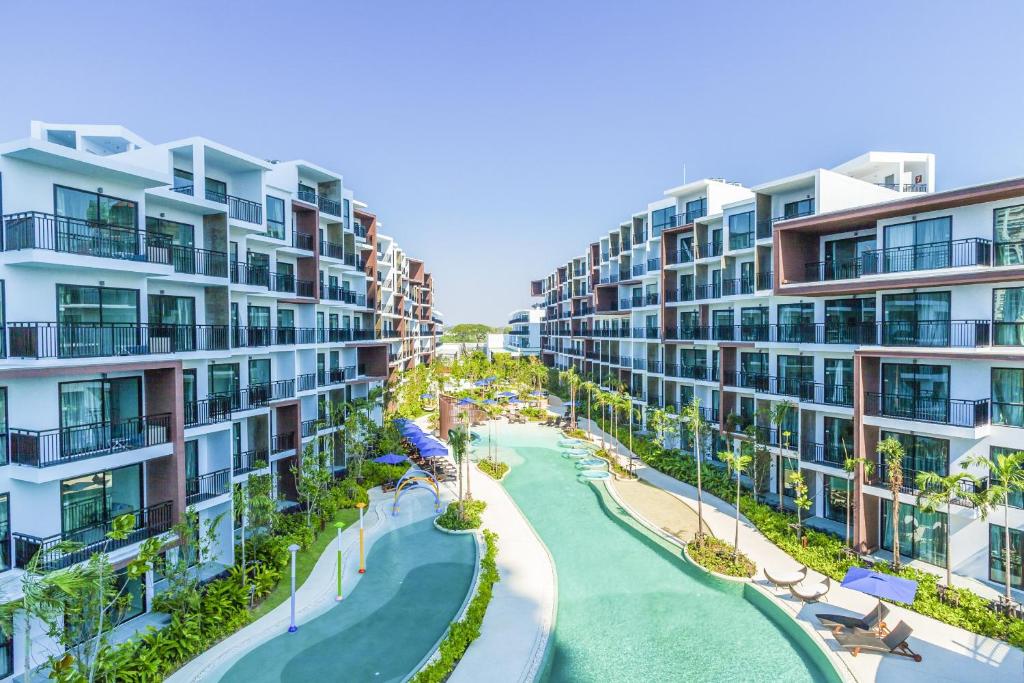 乔木提恩海滩Centara Life Maris Resort Jomtien的两栋公寓楼之间的河流空中景观