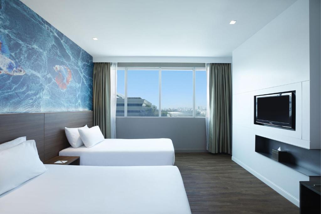 曼谷Centara Life Government Complex Hotel & Convention Centre Chaeng Watthana的酒店客房设有两张床和一台平面电视。