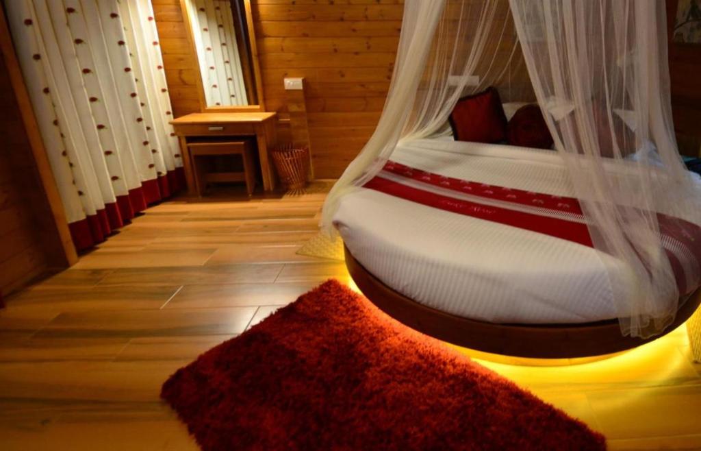 卡尔佩特塔Room in Villa - LakeRose Wayanad Resort的一间卧室配有一张带天蓬和地毯的床
