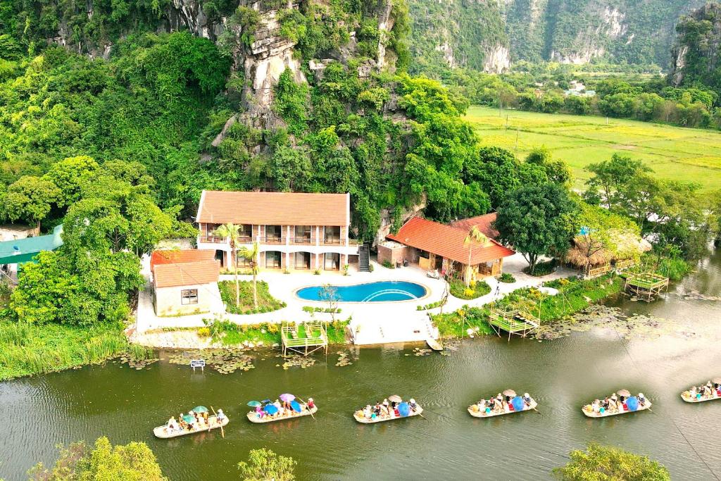 宁平HoangLong Riverside Homestay的水中船只房屋的空中景观