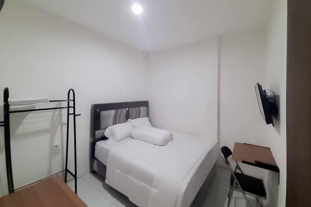 GedegRedDoorz near Alun Alun Kota Serang的白色卧室配有床和椅子