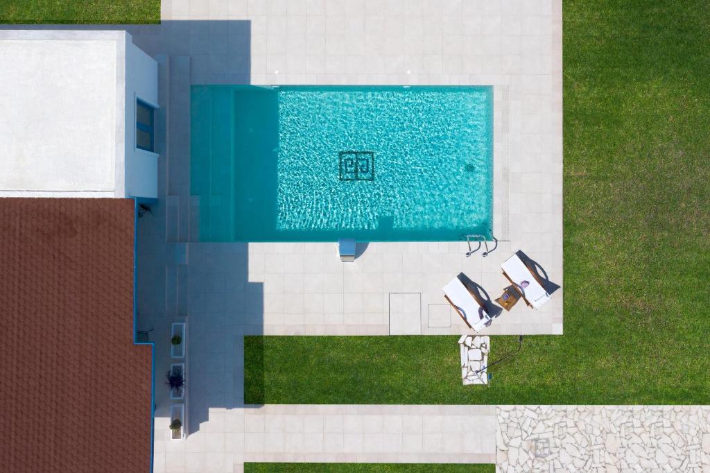 科林比亚Serenity Villas的享有带两把椅子的游泳池的顶部景致