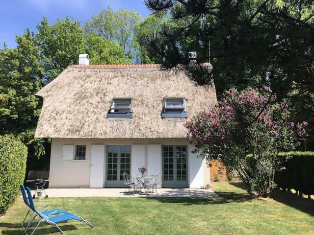 厄镇Le Lodge des Prés的一间有稻草屋顶的小白色房子