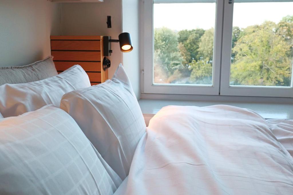 斯德哥尔摩拉格霍尔门酒店的一间卧室配有两张带白色床单的床和两个窗户。
