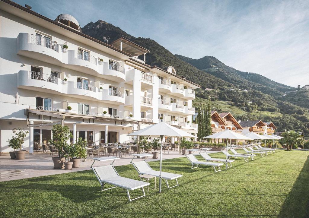 拉古多Hotel MARIA THERESIA adults-only的草坪上配有椅子和遮阳伞的酒店