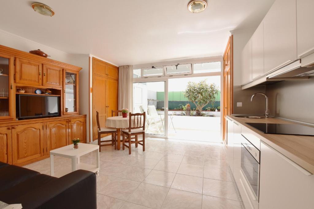 蒂亚斯Colina del Sol Lanzarote Pool with sea view的厨房以及带桌椅的起居室。