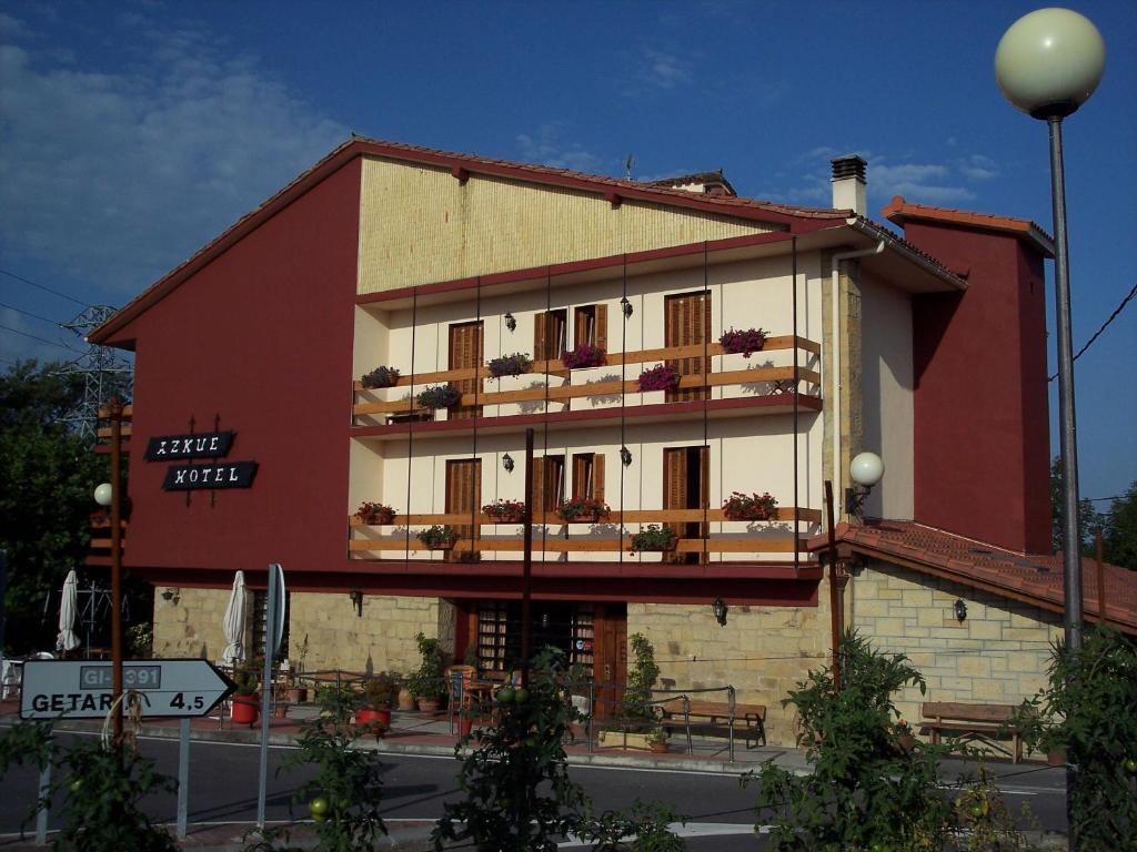 吉塔里亚阿兹库酒店的一座红白色的建筑,在街上设有阳台