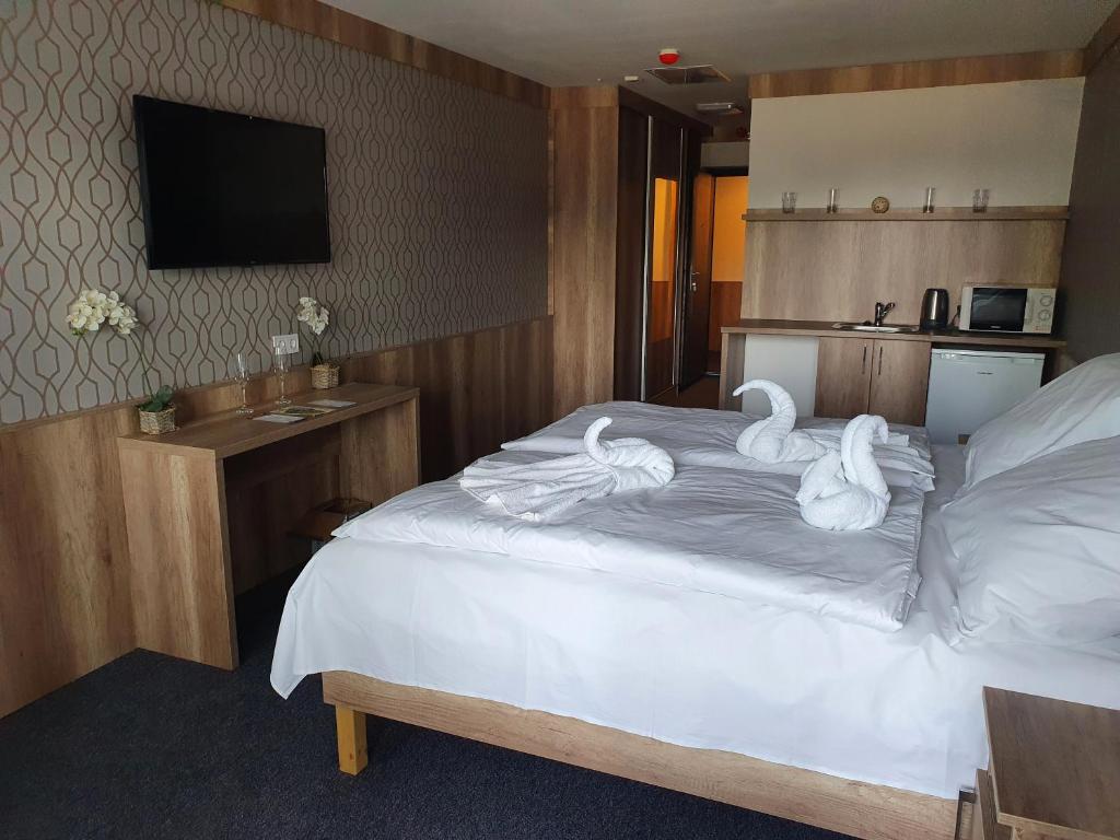 帕波miniHotel Pápa的酒店客房,床上有天鹅