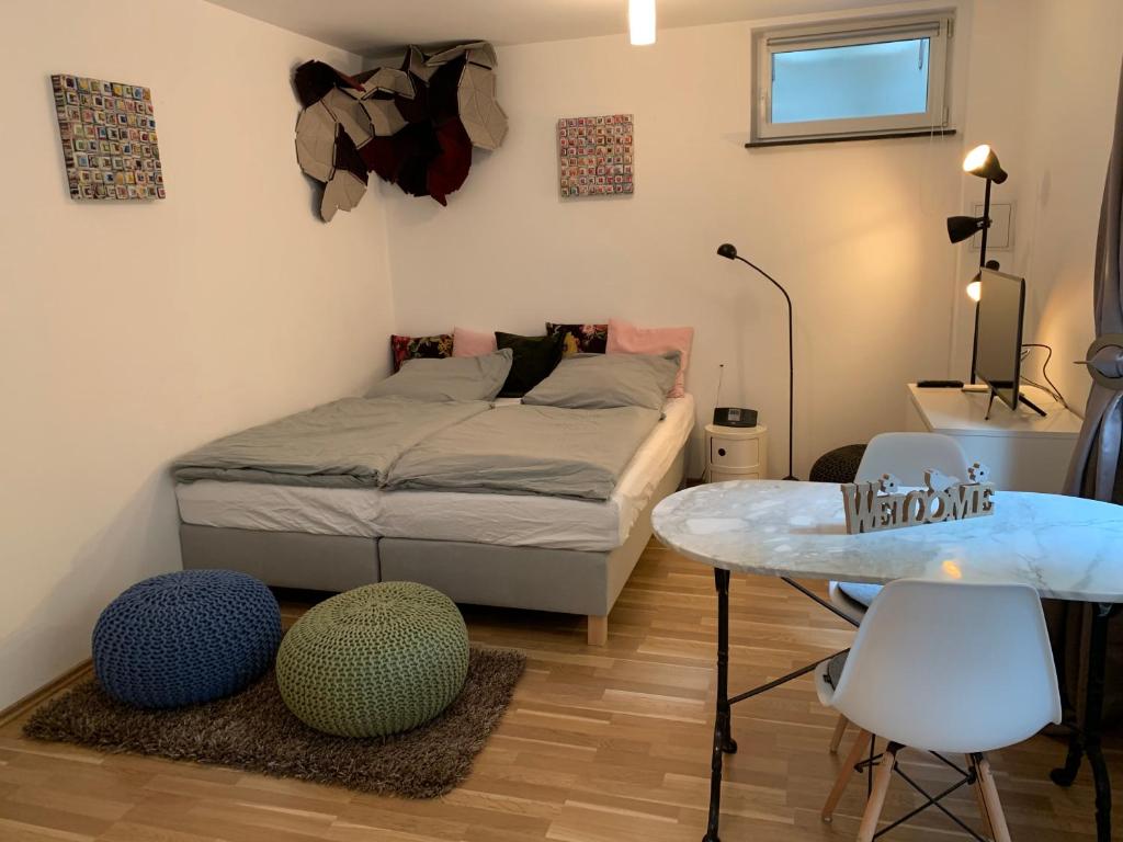 慕尼黑Helle Souterrainwohnung mit Komfort的卧室配有一张床和一张桌子及椅子