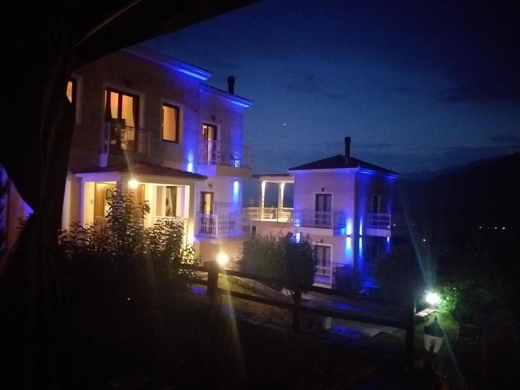 卡兰巴卡埃帕维利斯米特奥拉套房酒店 的夜晚亮着蓝色灯的房子