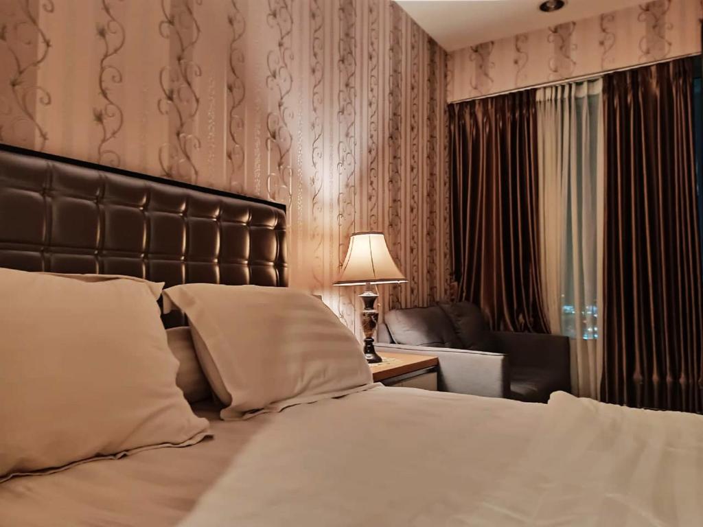 贝克西Apartemen grand kamala lagoon by 21 Room的一间卧室配有床、沙发和灯