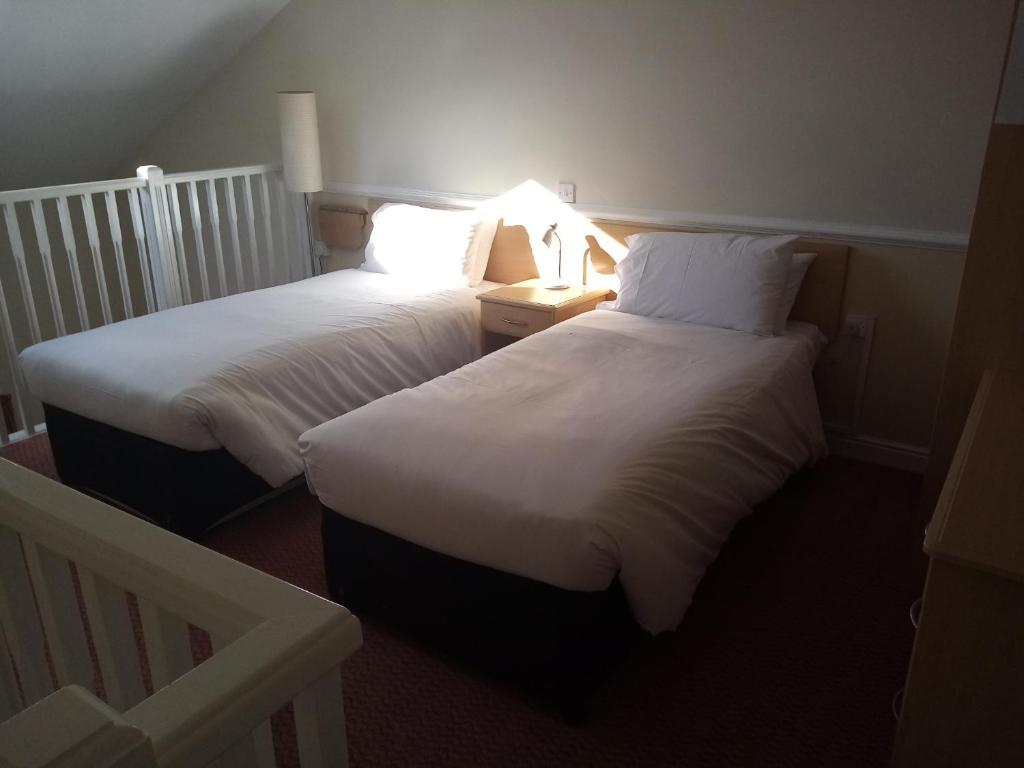 彻克莫尔顿公园酒店的两张位于酒店客房的床,光线充足