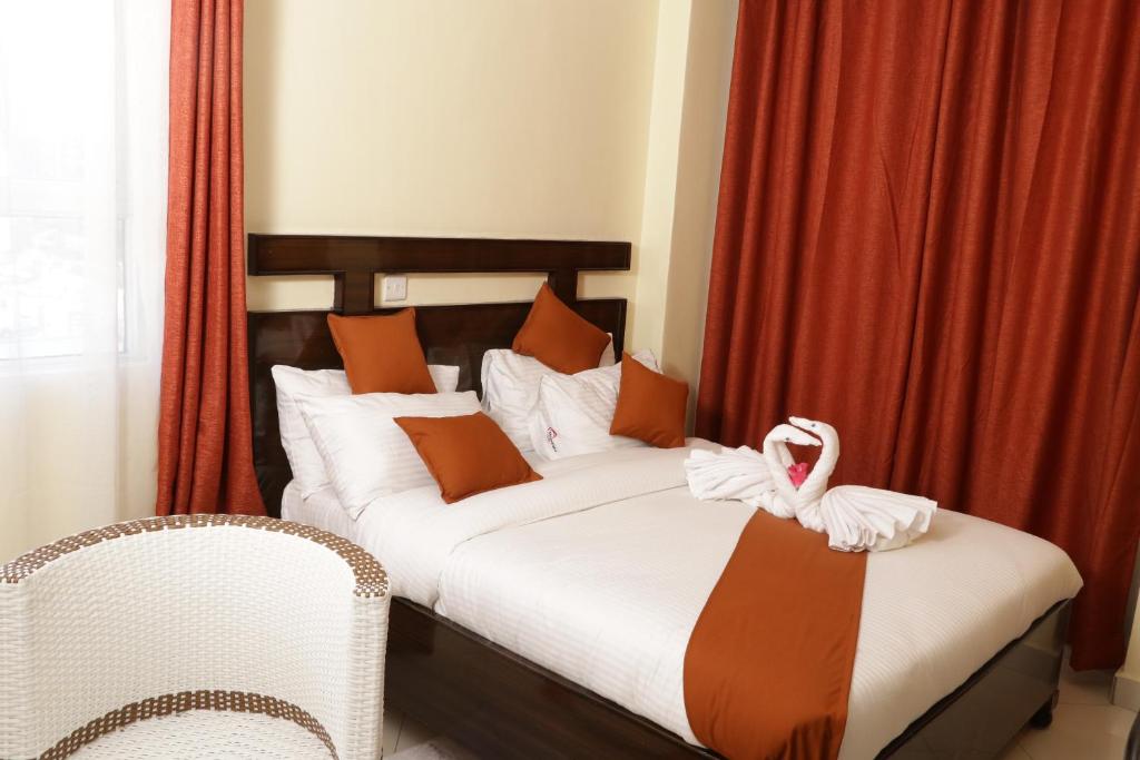 纳库鲁Claire de Lune Moonlight Hotel的一间卧室配有一张带天鹅的床