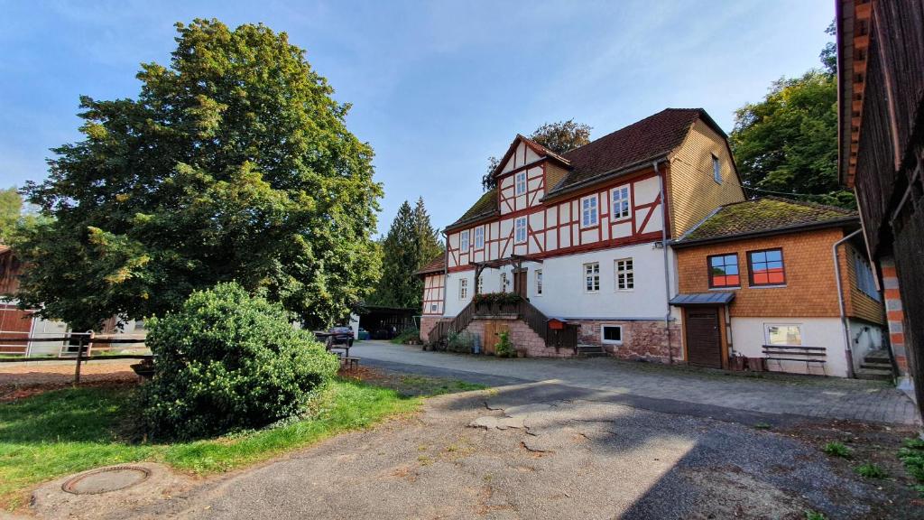 巴特赫尔斯费尔德Ferienwohnung auf idyllischen Gestüt auf historischen Gutshof in Hessen的街上一座白色和红色的大房子