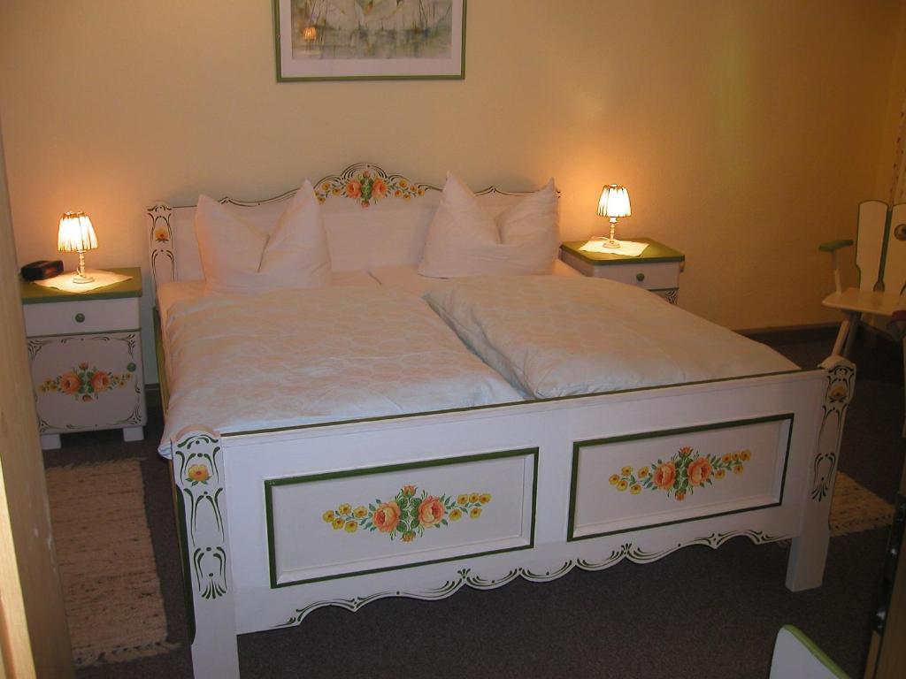 比绍夫斯格林Ferienwohnungen Frosch的一间卧室配有白色床和2个床头柜