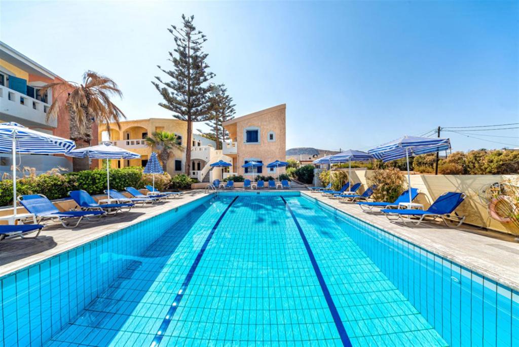 库基尼坎尼奥Niros Beachfront Aparthotel的一个带蓝色椅子和遮阳伞的大型游泳池