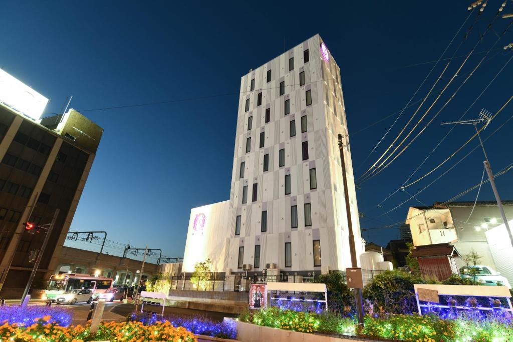 奈良Hotel Wisteria NARA的夜晚在城市里高大的白色建筑