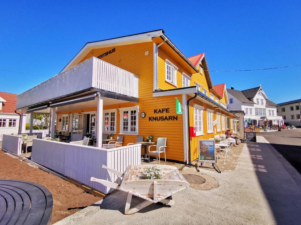 亨宁斯韦尔Henningsvær Guesthouse的前面有一张桌子的黄色建筑