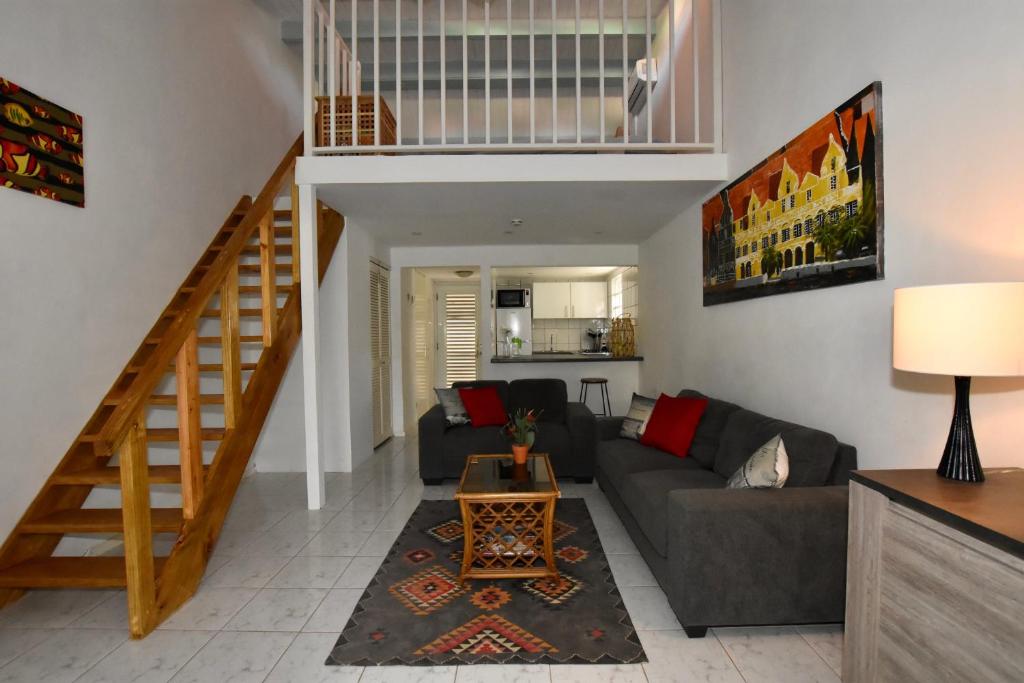 威廉斯塔德Seru Coral Apartment的带沙发和楼梯的客厅
