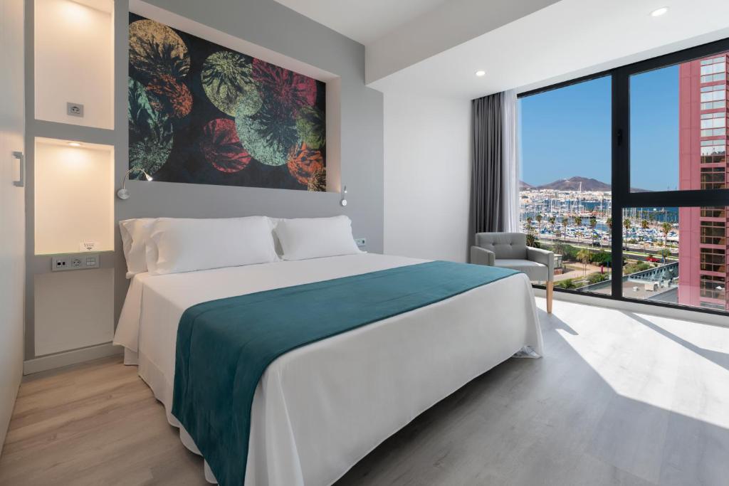 大加那利岛拉斯帕尔马斯Occidental Las Palmas的一间卧室设有一张大床和一个大窗户