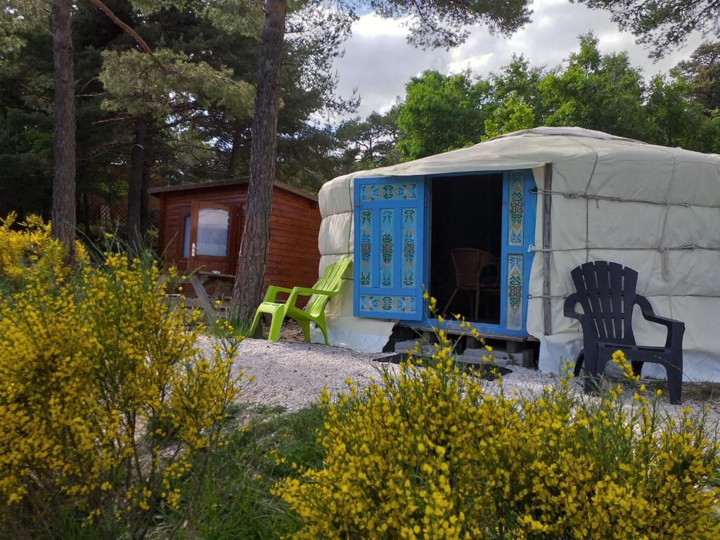 卡斯特拉讷艾罗斯山林小屋的蒙古包,带蓝色门和绿色椅子