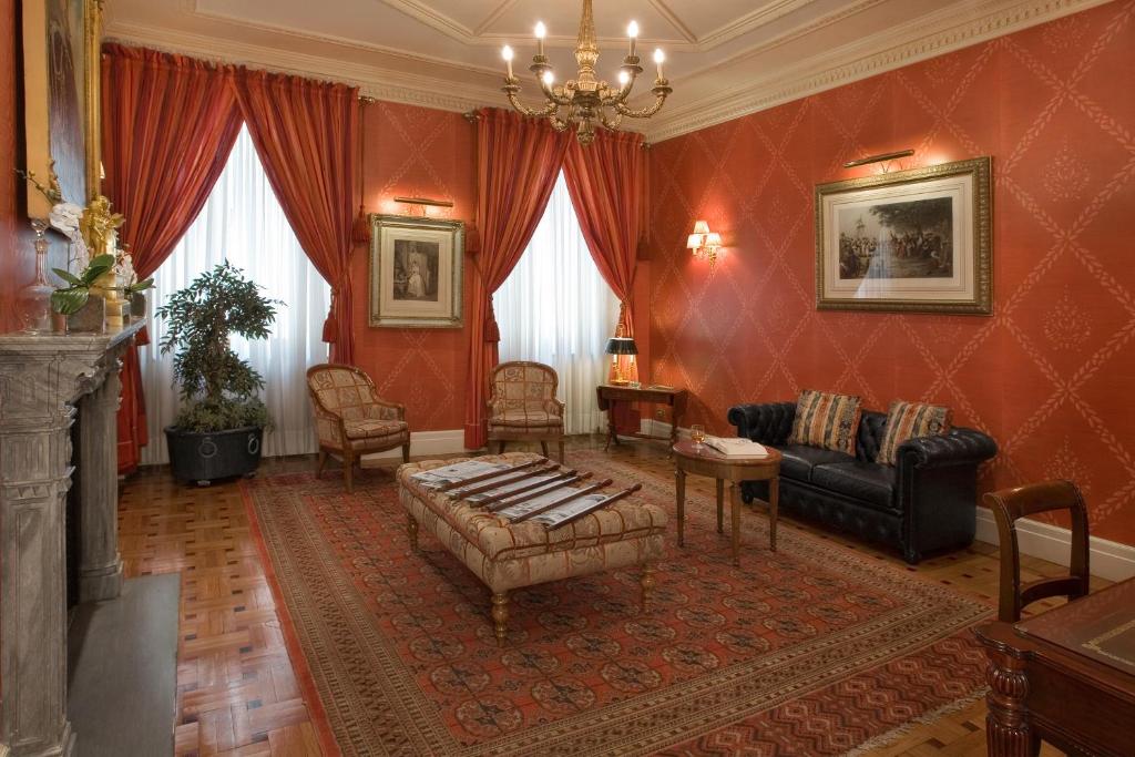 都灵西太大酒店的客厅配有沙发和桌子