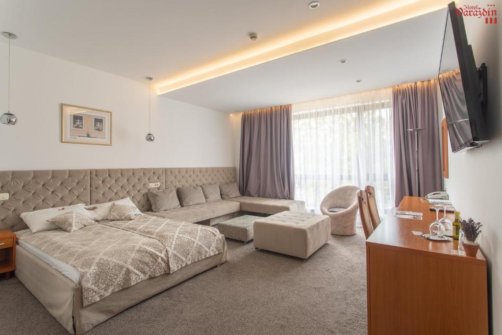 瓦拉日丁Hotel Varazdin的一间卧室配有一张床、一张沙发和一台电视。