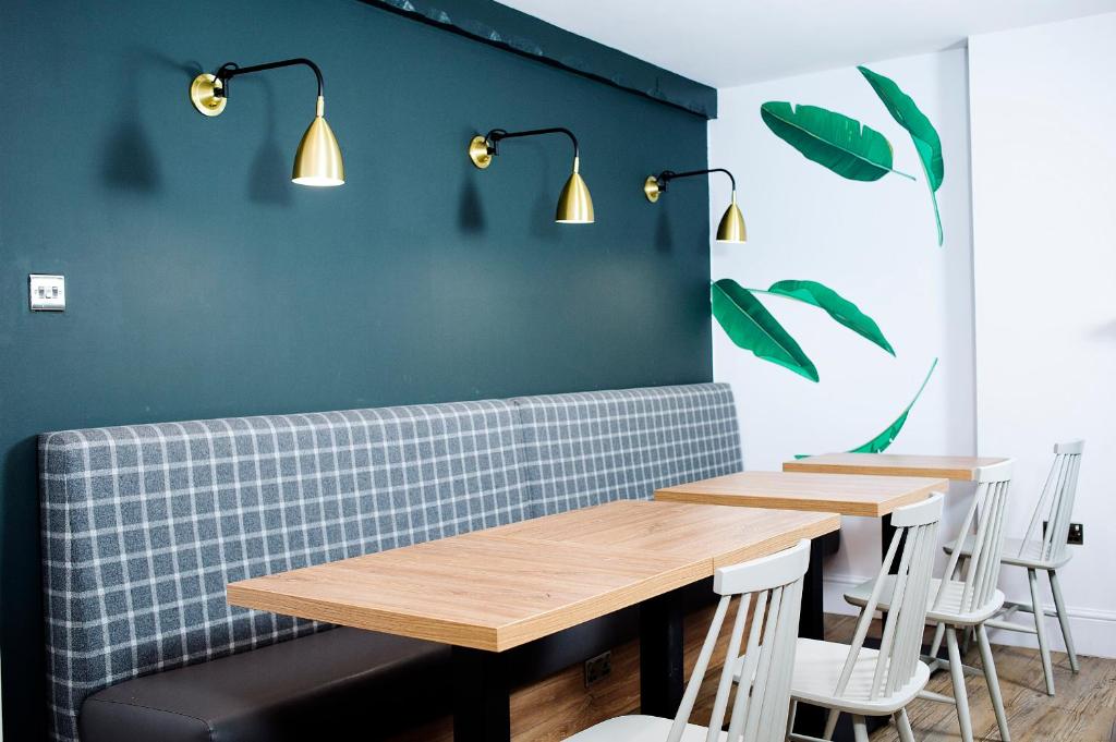 格拉斯哥阿盖尔酒店的一间设有两张桌子和蓝色墙壁的用餐室