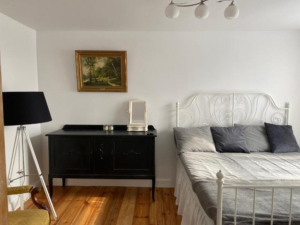 斯克伦达Skrunda Apartments Rustic的一间卧室配有一张带黑色梳妆台和灯的床。
