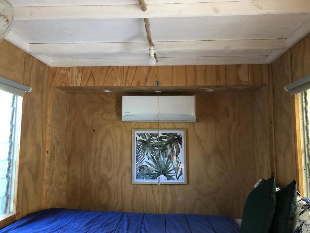 耐莉湾SEA-green的卧室配有一张床,墙上挂着一幅画