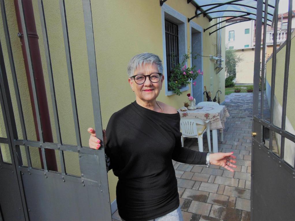 乌迪内AVD - La Nuova Casa di Nonna的门廊上开着门的老年妇女
