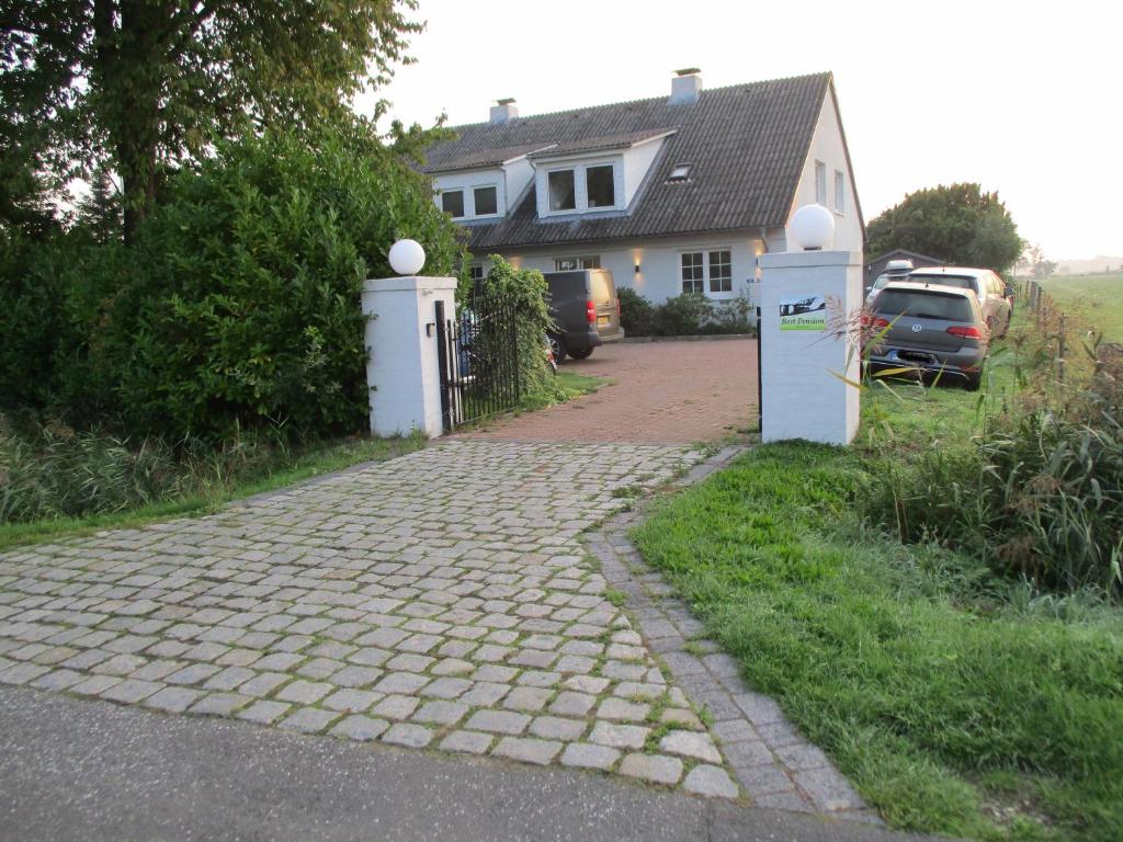 格吕克斯塔特Best Pension的房屋前有砖砌车道的房子