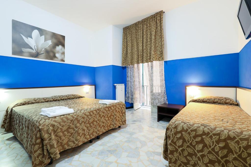 热那亚迷你酒店的酒店客房,设有两张床和蓝色的墙壁