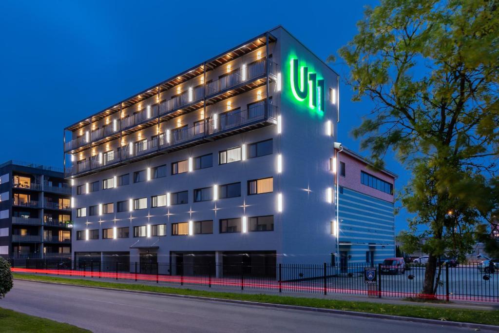 塔林U11 Hotel & SPA的上面有灯的标志的办公楼
