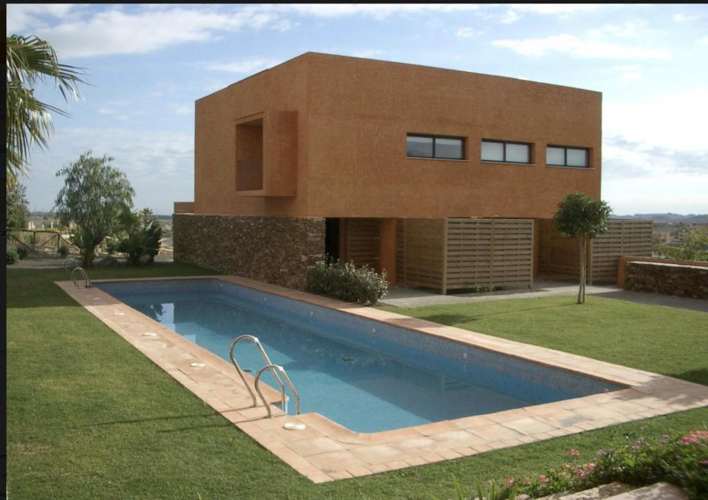 维拉Preciosa Casa de diseño Valle del Este Golf Resort ideal para familias的房屋前有游泳池的房子