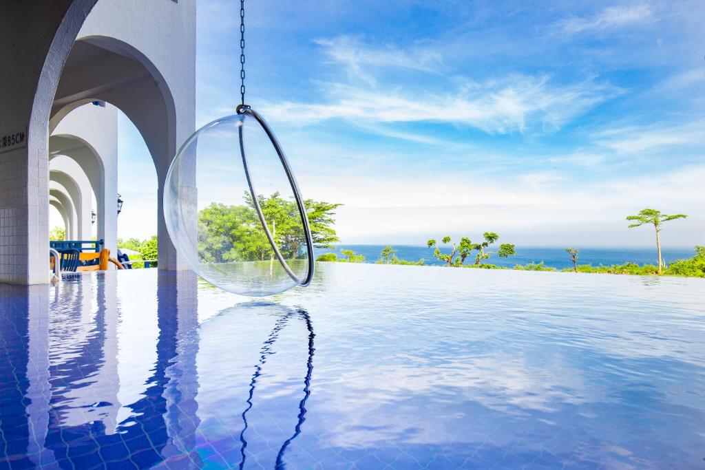 小琉球岛小琉球地中海海景旅店的悬挂在游泳池边的玻璃棒秋千