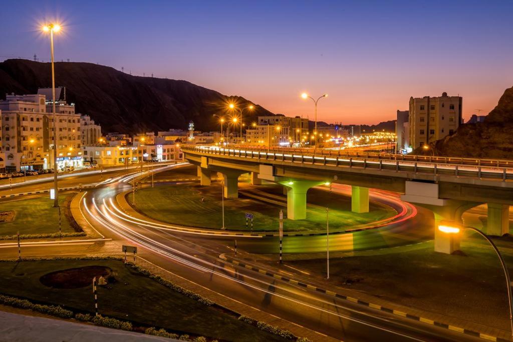 马斯喀特Al Jisr Hotel的夜间有车在高速公路上行驶的桥梁