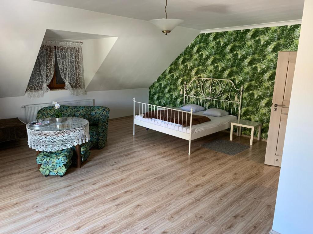 Boczów乌奥卡汽车旅馆的一间设有婴儿床和椅子的客房,以及绿色的墙壁