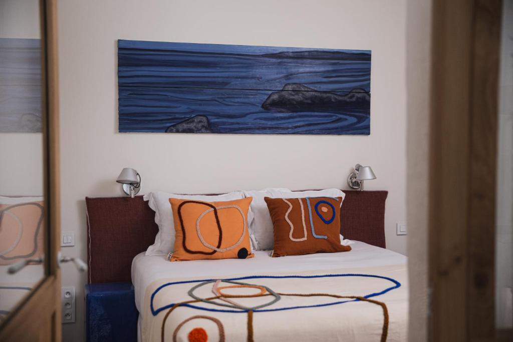 塞特港Suites The Marcel的一张带橙色枕头的床和墙上的绘画